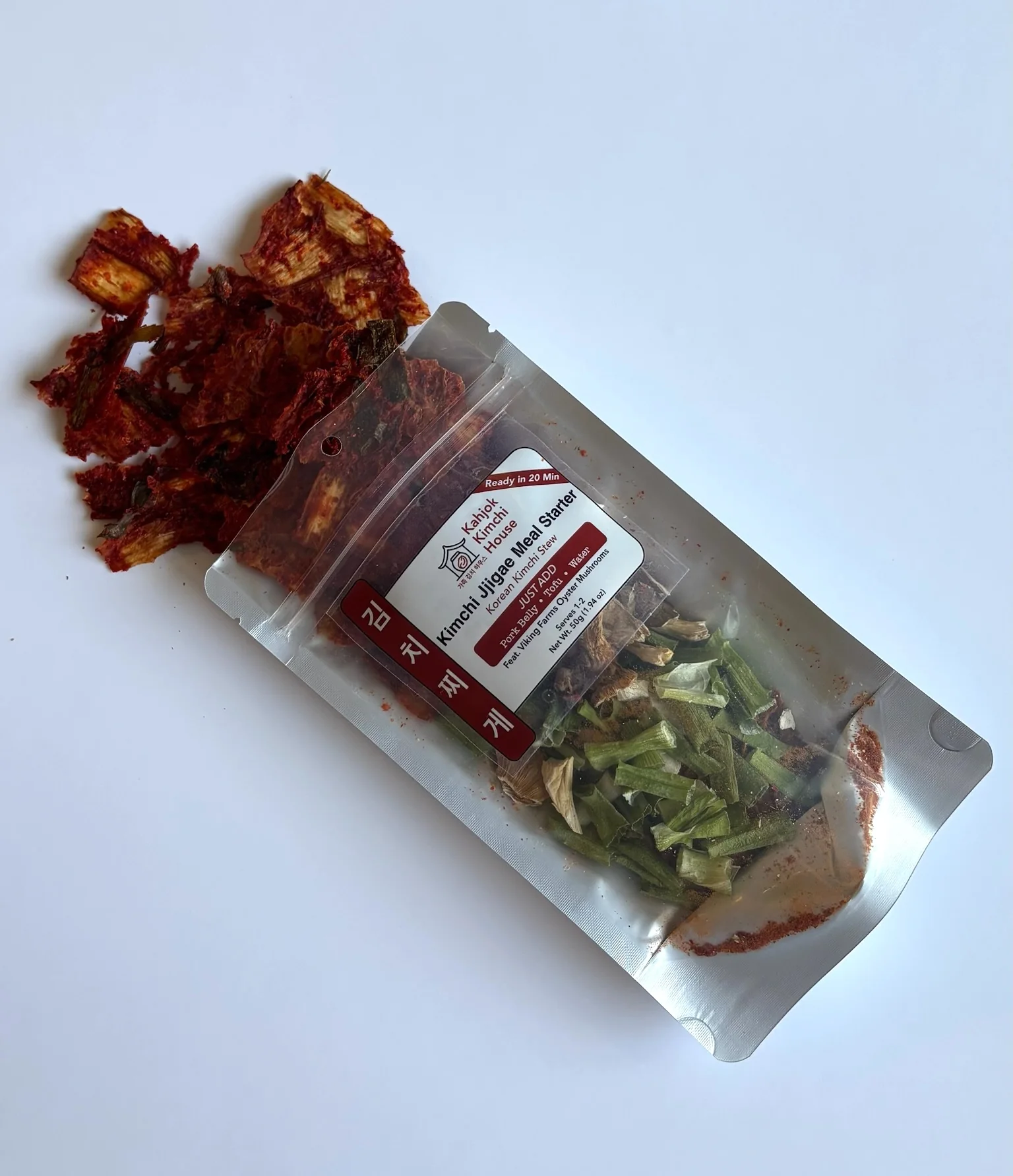 Kimchi Jjigae Meal Starter package with dried kimchi spilling onto a white surface